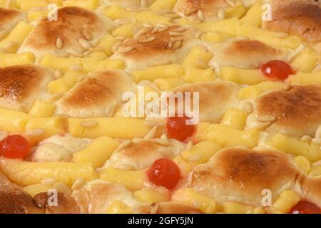 close up of sponge cake of egg cream, pine nuts and cherries on white background Stock Photo