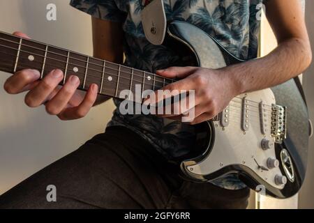 Closeup shot of a young male hands practicing playing guitar Stock Photo