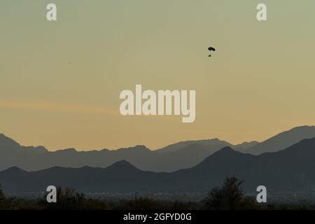 A powered parachute or PPC flies over Quartzsite, Arizona with the Dome Rock Mountains in the background. Stock Photo