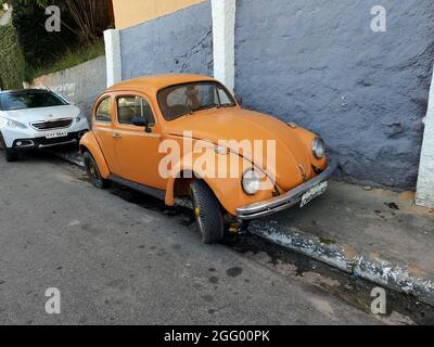 June 9, 2021. São Paulo, Brazil. An old Volkswagen Beetle parked on the sidewalk in a narrow street in São Paulo. Stock Photo