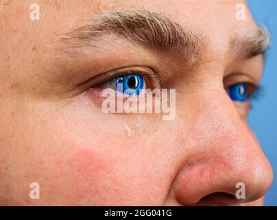 Ophthalmologist concept. Mans eye with contact lens, closeup. Man with blue eyes Stock Photo