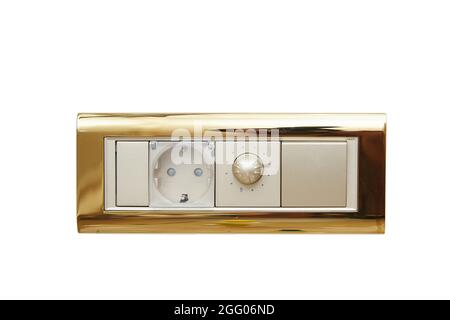 wall-mounted electric switch or socket in a gold-plated frame on a white isolated background. Stock Photo