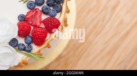 Top shot of the cake with space for text. Cake with raspberries and blueberries