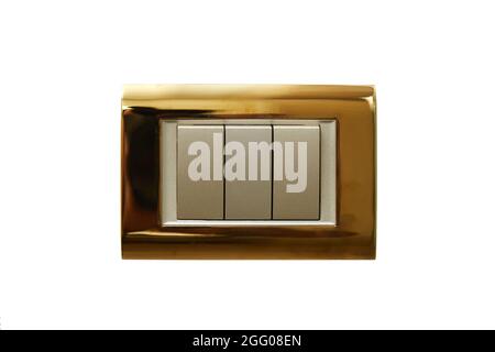 wall-mounted electric switch or socket in a gold-plated frame on a white isolated background. Stock Photo