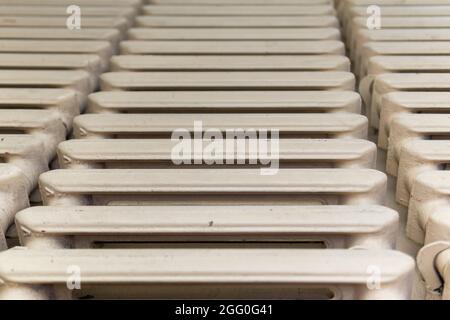 Old painted heating radiator. Pink dirty color. View from the front. Stock Photo
