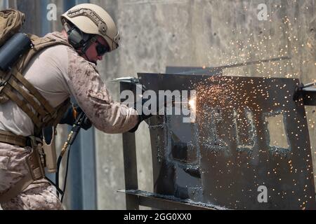 A U.S. Marine with 4th Platoon, Force Reconnaissance Company, III Marine Expeditionary Force, cuts through a steel plate with a thermal cutting tool during mechanical and thermal breaching training on Camp Hansen, Okinawa, Japan, Aug. 25, 2021. This training taught Marines proper techniques for breaching steel plates using different tools which enables them to be more proficient in the field. (U.S. Marine Corps photo by Lance Cpl. Zachary Sarvey) Stock Photo