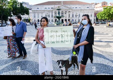 Lisbon, Portugal. 27th Aug, 2021. Activists holding a placard expressing their opinion, during the rally. The feminist collective, Por Todas Nos organized a rally in defense of Afghan women and children at Rossio Square, and presented an initiative that was signed by 18 groups and associations and has more than 150 individual signatures proposing to increase the quota of refugees. At the rally, testimonies of women from Afghanistan were read. Credit: SOPA Images Limited/Alamy Live News Stock Photo