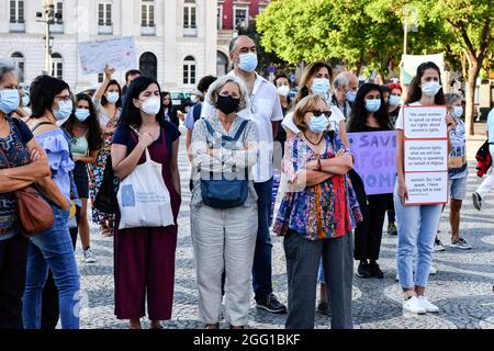 Lisbon, Portugal. 27th Aug, 2021. Activists listening to speeches during the rally. The feminist collective, Por Todas Nos organized a rally in defense of Afghan women and children at Rossio Square, and presented an initiative that was signed by 18 groups and associations and has more than 150 individual signatures proposing to increase the quota of refugees. At the rally, testimonies of women from Afghanistan were read. Credit: SOPA Images Limited/Alamy Live News Stock Photo