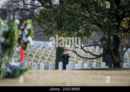 A bugler from The U.S. Army Band, “Pershing’s Own”, plays taps during the funeral of U.S. Army Sgt. 1st Class Mihail Golin in Section 60 of Arlington National Cemetery, Arlington, Virginia, Jan. 22, 2018. Golin, an 18B Special Forces Weapons Sergeant assigned to 10th Special Forces Group (Airborne) died Jan. 1, 2018, as a result of wounds sustained while engaged in combat operations in Nangarhar Province, Afghanistan.  Golin deployed to Afghanistan in September 2017 with the 2nd Battalion, 10th Special Forces Group, in support of Operation Freedom’s Sentinel.  Golin enlisted Jan. 5, 2005 and t Stock Photo