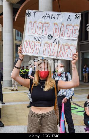 London, UK. 27th Aug, 2021. A protester holds a placard reading "I want a hot date not a hot planet" during the Extinction Rebellion's Impossible Rebellion Blood Money march by Decolonise the Economy' claiming the City of London was built on Blood Money. (Photo by Dave Rushen/SOPA Images/Sipa USA) Credit: Sipa USA/Alamy Live News Stock Photo