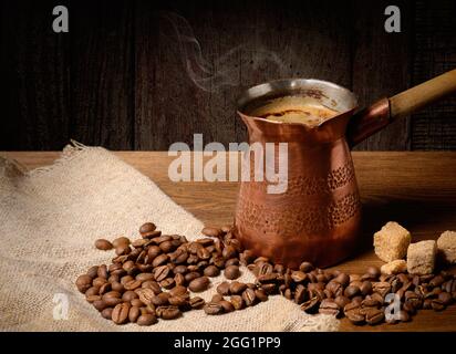 Cezve turk with hot coffee on wooden background Stock Photo