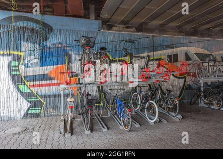 Bicycles on the bike stand in front of a graffiti wall Stock Photo