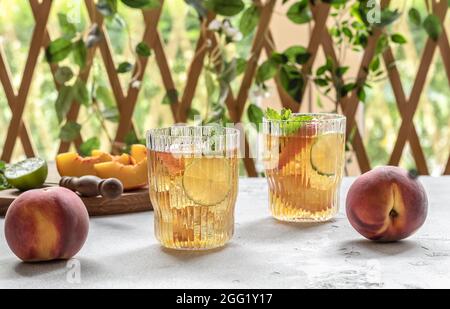 Two glasses with homemade peach ice tea or lemonade with mint.  Stock Photo