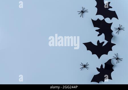 Background Halloween. Paper bats and spiders lie on a black background, copying space, flat layout Stock Photo