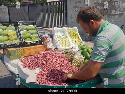 Beirut, Lebanon. 27th Aug, 2021. A vendor sells fresh pistachios on the roadside in Nabatiyeh, Lebanon, Aug. 27, 2021. In the Middle East, people call pistachio the 'smiling nut' because the split shell resembles a smile. The cultivation of pistachio began to recover and expand in Lebanon several years ago, benefiting from the assistance of local and international agricultural associations. Credit: Taher Abu Hamdan/Xinhua/Alamy Live News Stock Photo