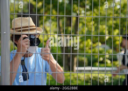 Tokio, Japan. 28th Aug, 2021. Paralympics: Athletics, at the Olympic Stadium. A man takes a photo on the grounds around the Olympic Stadium. Credit: Marcus Brandt/dpa/Alamy Live News Stock Photo