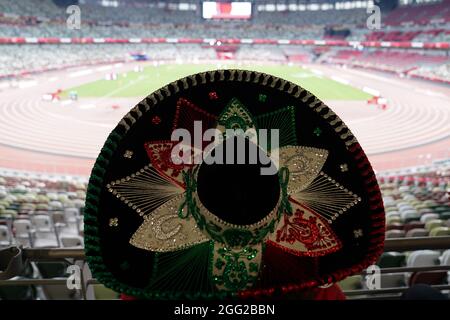 Tokio, Japan. 28th Aug, 2021. Paralympics: Athletics, at the Olympic Stadium. A person wearing a Mexican sombrero watches the track and field competitions. Credit: Marcus Brandt/dpa/Alamy Live News Stock Photo