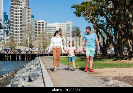 happy young mom and dad walking in park with son, adoption Stock Photo