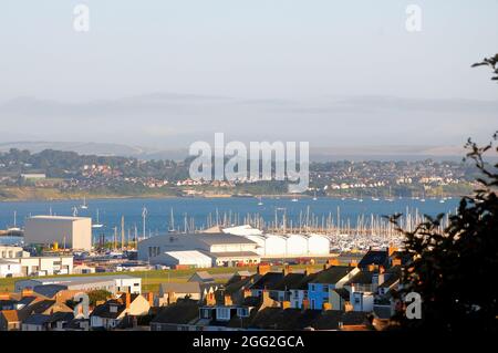 Portland. 28th August 2021. Uk Weather. Low, early morning sunshine catches the yacht masts in Portland harbour. Credit: stuart fretwell/Alamy Live News Stock Photo