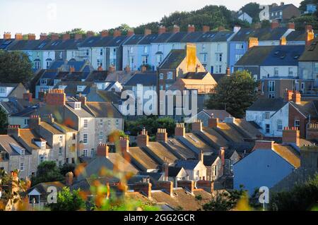 Portland. 28th August 2021. UK Weather. Low, early morning sunshine rakes across the rooftops in Fortuneswell on the Isle of Portland. Credit: stuart fretwell/Alamy Live News Stock Photo