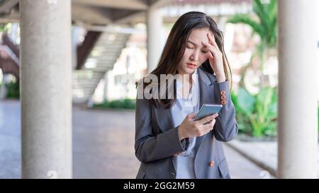 Working woman concept a young businesswoman fatigued after doing a load of work and spending too much time on electronic devices. Stock Photo