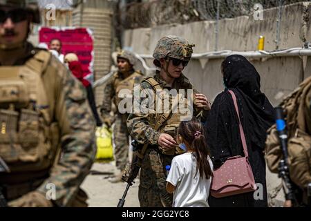 Kabul, Afghanistan. 28th Aug, 2021. A Marine assists a woman and child during an evacuation at Hamid Karzai International Airport, in Kabul, Afghanistan, on August 18, 2021. U.S. service members are assisting the Department of State with an orderly drawdown of designated personnel in Afghanistan. Photo by 1st Lt. Mark Andries/USMC/UPI Credit: UPI/Alamy Live News Stock Photo