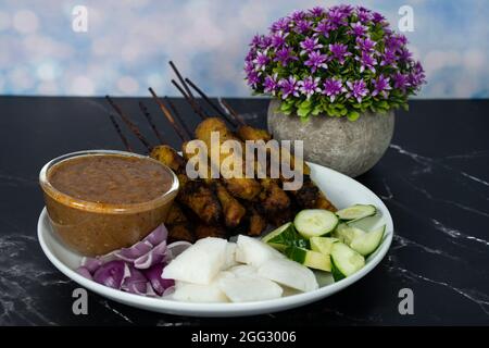 Satay is skewered meat on a bamboo stick then grilled on charcoal fire eaten with peanut gravy. Satay is a famous street food in South East Asia. Sele Stock Photo