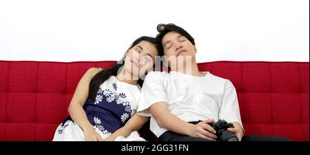 Asian couple falling asleep on the sofa after finishing the photo shoot in the studio. Stock Photo