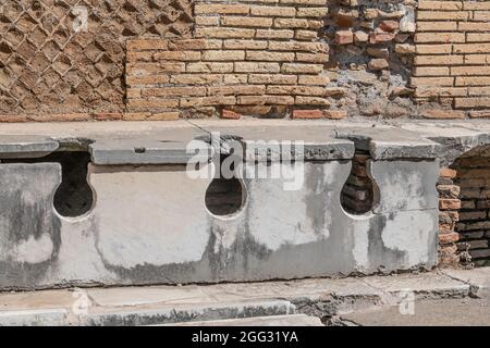 Latrina presso le terme del foro. Ancient public toilets (latrines) located at Ostia Atica (the ancient port of Rome) Stock Photo