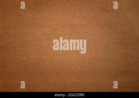 Sandpaper texture background where you can see the red-brown sand grain pattern on the sandpaper, suitable as a background for inserting text Stock Photo