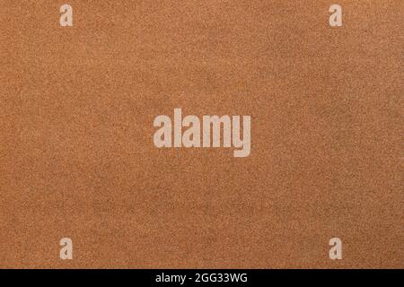 Sandpaper texture background where you can see the red-brown sand grain pattern on the sandpaper, suitable as a background for inserting text Stock Photo