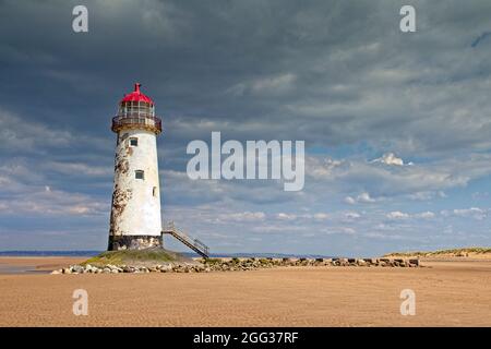 Point of Ayr Lighthouse on the north west tip of the Dee Estuary.  Heavy grey clouds with bright sunshine. Low tide with sandy shore around lighthouse Stock Photo