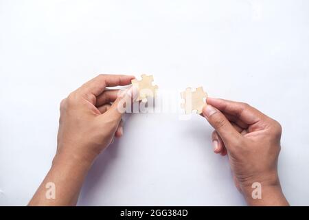 man hand hold connecting puzzle on table  Stock Photo