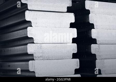 aluminum ingots, in 'T' shape,  stacked in the warehouse waiting for meltting, Industrial photo in black and white Stock Photo