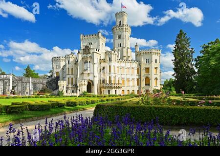 Beautiful old state chateau Hluboká nad Vltavou. View from the outdoor garden in summer with blue sky, sun and clouds. Stock Photo