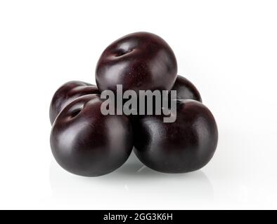 Pyramid of ripe juicy whole black plums isolated on white background. Ready to eat fresh ripe sweet plums. Design element for vegetarian  vegan food. Stock Photo