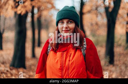 Attractive caucasian woman hiking trip backpack in autumn forest Stock Photo