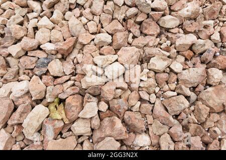 Closeup of a surface covered with small light brown stones and gravel covering the surface of an urban land Stock Photo