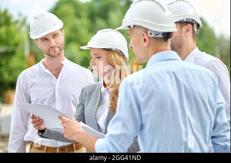 Serious female inspector focused on checking building documentation Stock Photo