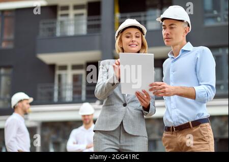 Smiling supervisor and a male worker examining a ceramic tile Stock Photo
