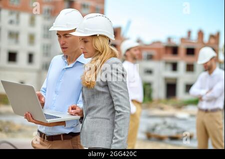 Building inspector and a worker staring at the computer monitor Stock Photo