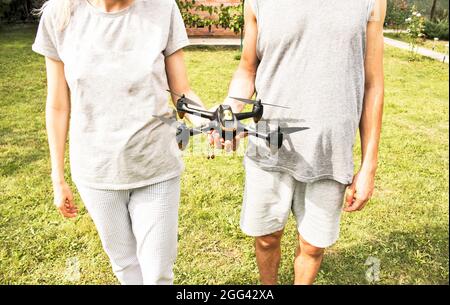 Young man and woman are holding a drone in their hands. With the help of a quadcopter, you can take photos and videos. Stock Photo