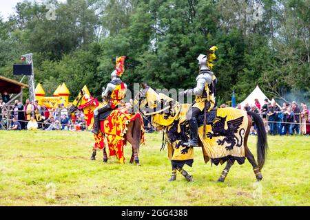 8th August 2021 - Knights in armour on horseback during jousting tournament at Medieval festival Loxwood Joust, West Sussex, England, UK Stock Photo