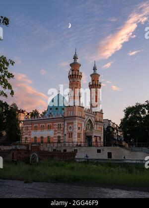 View on Sunni Mukhtarov Mosque in front of summer evening sky with crescent moon and pink clouds on the bank of Terek river in Vladikavkaz city, North Stock Photo