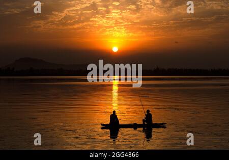 Srinagar, Indian-controlled Kashmir. 28th Aug, 2021. Fishermen catch fish in Dal Lake at sunset in Srinagar, the summer capital of Indian-controlled Kashmir, on Aug. 28, 2021. Credit: Javed Dar/Xinhua/Alamy Live News Stock Photo