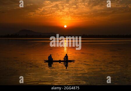 Srinagar, Indian-controlled Kashmir. 28th Aug, 2021. Fishermen catch fish in Dal Lake at sunset in Srinagar, the summer capital of Indian-controlled Kashmir, on Aug. 28, 2021. Credit: Javed Dar/Xinhua/Alamy Live News Stock Photo