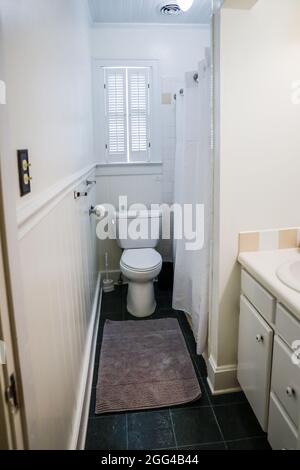 White bathroom sink with vintage tiles, and toilet in old cottage guest bathroom Stock Photo