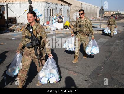 Paratroopers assigned to the 82nd Airborne Division carry bags of baby supplies to families in need during an infant needs drive at Hamid Karzai International Airport in Kabul, Afghanistan, August 26, 2021. The drive was hosted by the 82nd Abn. Div. chaplain's office who procured baby formula, diapers, juice, baby food and crackers for distribution to Afghan families who are evacuating the country. The supplies are meant to help sustain the families on their journey.      (U.S. Army photos by Master Sgt. Alexander Burnett, 82nd Airborne Division) Stock Photo