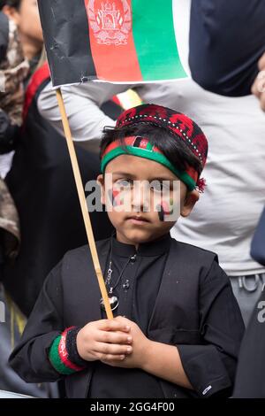London, UK. 28th Aug, 2021. An Afghan child with the Afghanistan flag colours, during the demonstration in Westminster.The Afghans rallied in London organised by The Watan, to condemn acts of terrorism by the Taliban in Afghanistan. The Watan as an organisation raising awareness about current humanitarian crisis in Afghanistan and seeks to unite foreign forces to restore peace in the country. They demand that proxy wars be stopped now in Afghanistan. Credit: SOPA Images Limited/Alamy Live News
