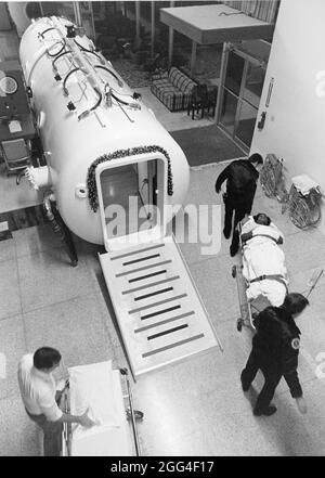 Austin Texas USA, circa 1992: Medical technicians prepare to put patient into hyperbaric chamber, used to treat carbon dioxide poisoning and other diseases. ©Bob Daemmrich Stock Photo